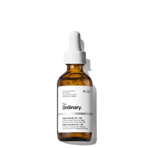A bottle of The Ordinary Alpha Arbutin 2% + HA serum placed on a clean, minimal surface. The clear serum and sleek packaging stand out against the neutral background, emphasizing its brightening and hydrating properties