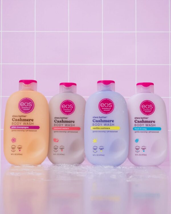 Four bottles of EOS Shea Better Cashmere Body Wash in Pink Champagne, Coconut Waters, Vanilla Cashmere, and Fresh & Cozy scents, displayed against a pink tiled background, showcasing their gentle, pH-balanced formulas for smooth, nourished skin.