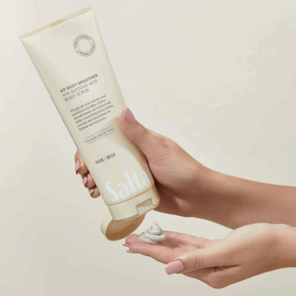 Hand squeezing Saltair KP Body Smoother scrub onto palm showing creamy, exfoliating texture