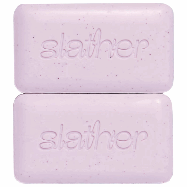 Topicals Slather Exfoliating and Smoothing Body Bar versus Faded Brightening and Cleansing Bar comparison on pink backdrop.
