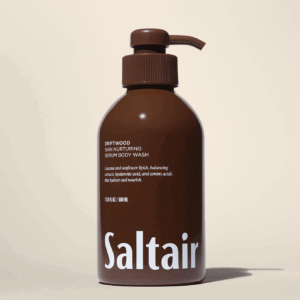 Saltair Driftwood Skin Nurturing Serum Body Wash pump bottle on a beige background.