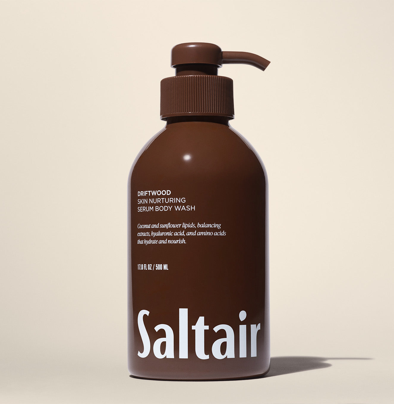 Saltair Driftwood Skin Nurturing Serum Body Wash pump bottle on a beige background.