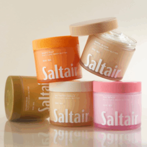 Saltair body butter collection including Exotic Pulp Pink Beach Santal Bloom Golden Hour and Salt Water Vanilla jars stacked together