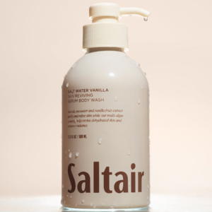 Saltair Salt Water Vanilla Skin Reviving Serum Body Wash bottle with water droplets on a neutral background