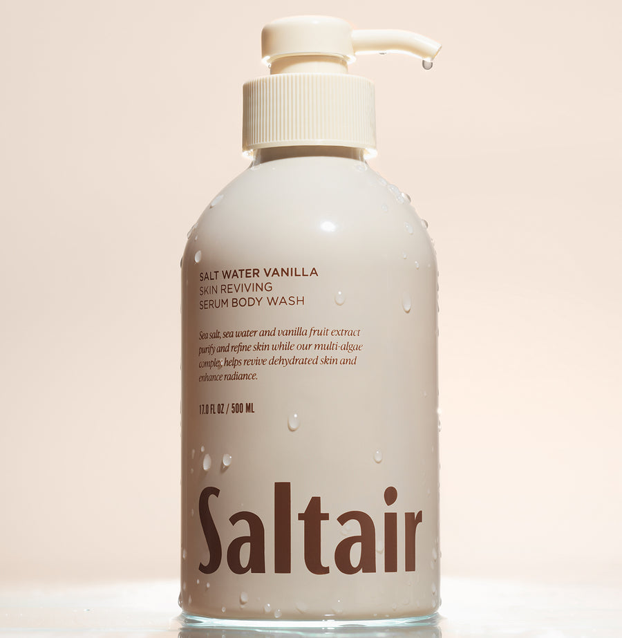 Saltair Salt Water Vanilla Skin Reviving Serum Body Wash bottle with water droplets on a neutral background